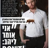 בחור ג'ינג'י עם שפם וזקן, לבוש חולצה לבנה מכופתרת ומכנס שחור, עומד כשיד שמאל בכיס מכנסיו.
