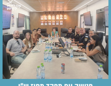 תמונה של מספר אנשים יושבים ליד שולחן ארוך
